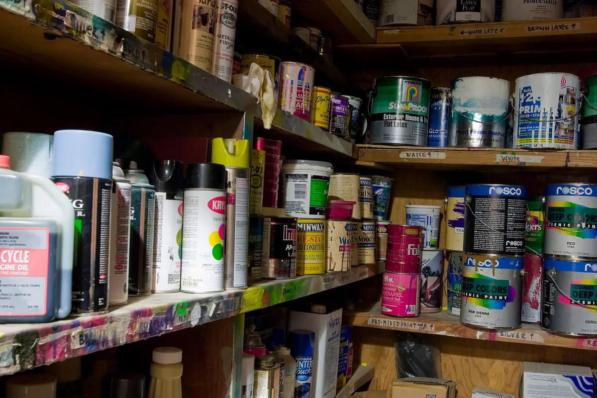 Shelves stacked with many cans of paint and spray cans