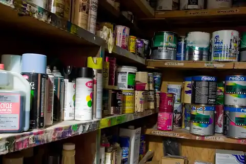Shelves stacked with many cans of paint and spray cans