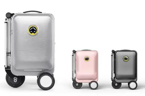 Silver smart electric suitcase with large wheels, beside two smaller pink and dark gray models