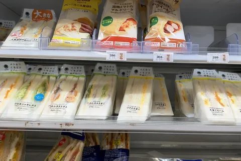 FamilyMart sandwiches on a chiller shelf in Tokyo on 20 October 2026; each wrapper names the fillings in English