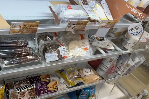 Cream puffs, eclairs and roll cakes on a FamilyMart dessert shelf in Tokyo on 20 October 2026, with Infinite Cream tags