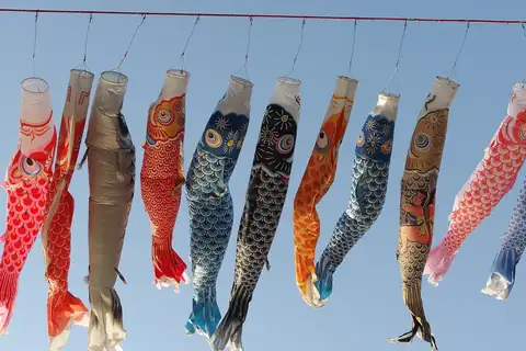 Colourful koinobori carp streamers hanging in a row from a red cord at a festival in Sagamihara