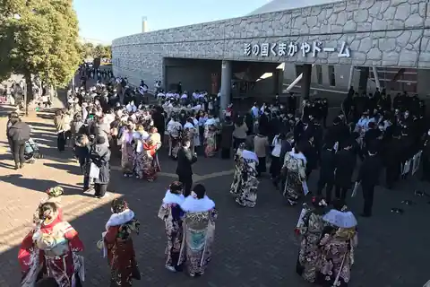 Young people in colourful furisode kimono and dark suits at a Coming of Age Day ceremony in Kumagaya