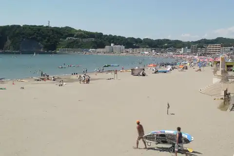 Zushi Beach in Kanagawa in summer, crowded with swimmers and beach umbrellas along the shore