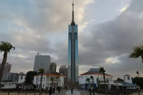 시사이드 모모치의 야자수와 하얀 해변 건물 위로 솟은 후쿠오카 타워, 아래로 걷는 사람들