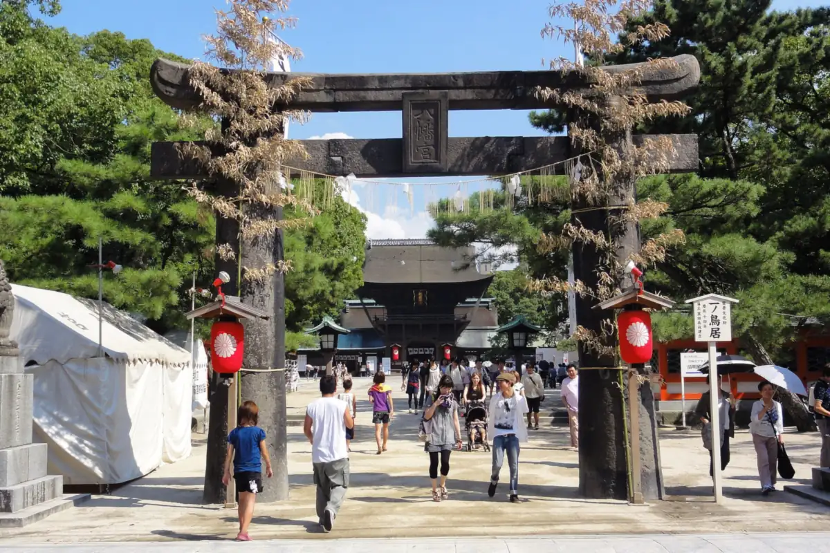 People walking toward the large torii gate of Hakozaki Shrine in Fukuoka during the Hojoya festival