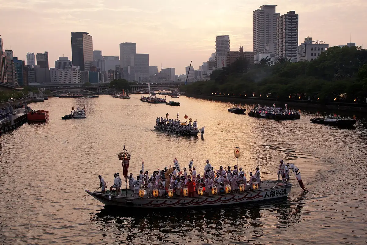 大阪・天神祭の行列中、大川に浮かぶ提灯飾りの船