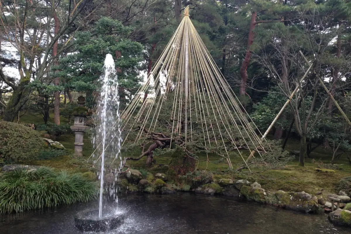 A fountain and a pine tree with cone-shaped yukitsuri ropes at Kenroku-en Garden, Kanazawa