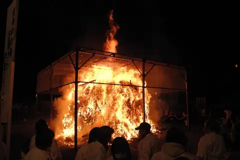 불축제의 밤, 금속 틀 안에서 타오르는 큰 불, 앞에서 흰옷 입은 사람들이 지켜봄