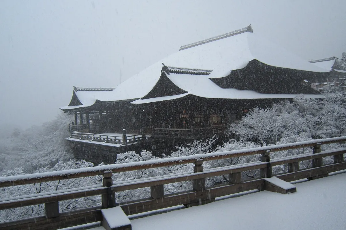 Snow falling on Kiyomizu-dera Temple in Kyoto, with its roofs and railings covered in snow