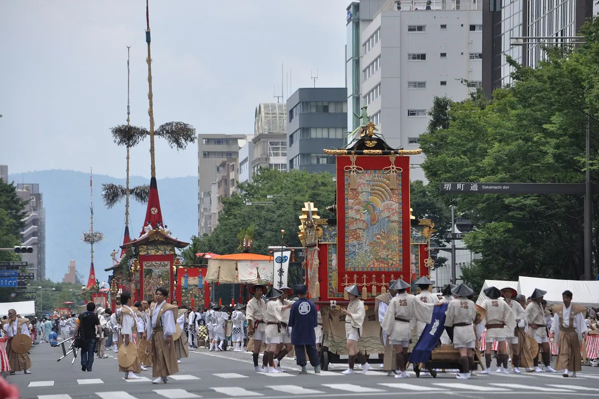 祇园祭以大型织锦装饰的花车，京都街道上穿轻便服饰的男子随行