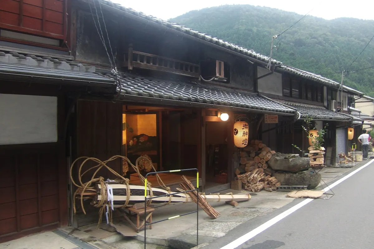 Bundled torches and piles of firewood in front of old wooden houses in Kurama village, Kyoto, during the Kurama Fire Festival