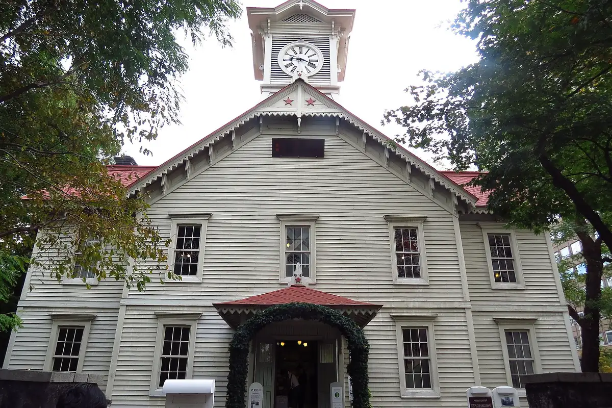 The Sapporo Clock Tower, a white wooden building with a clock face on its tower and a red roof