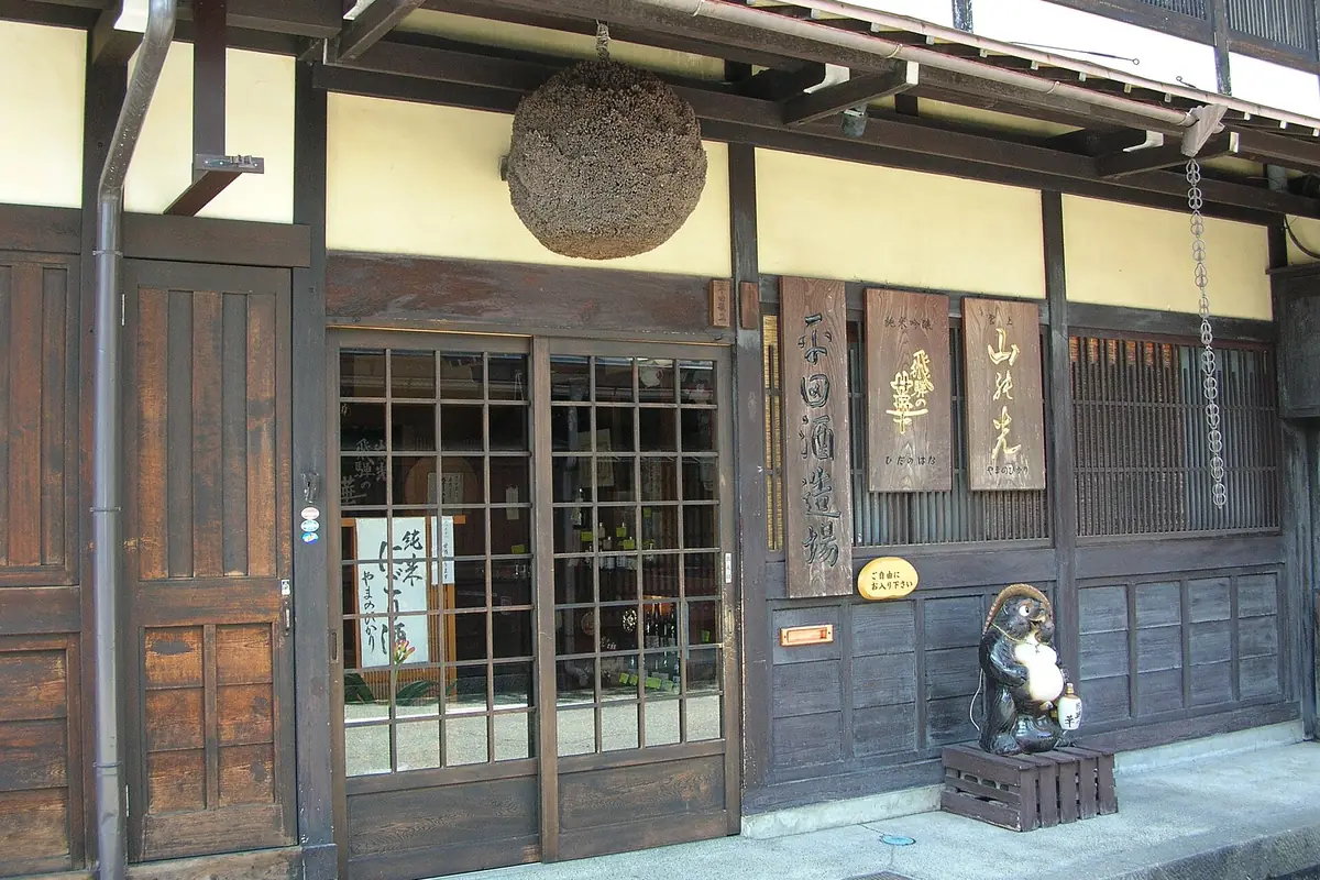 Traditional wooden sake brewery in Takayama with a cedar ball hanging under the eaves