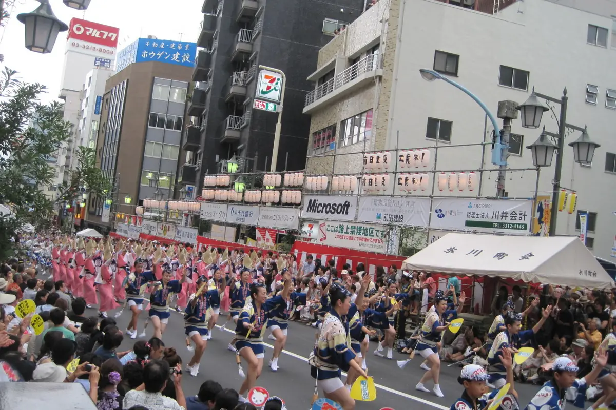 Awa Odori dancers parading along a street in Koenji, Tokyo, with spectators on both sides