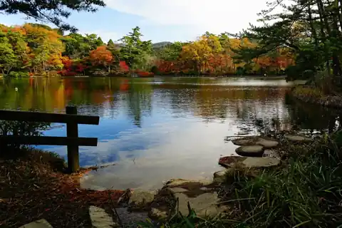Red, orange and yellow autumn leaves around a pond at Futatabi Park in Kobe