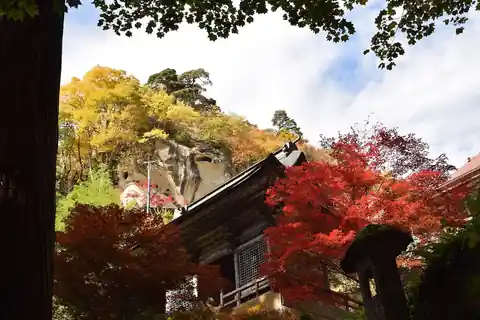 Red and yellow maple leaves beside a temple roof at Yamadera, Yamagata