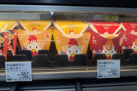 Karaage-kun Regular and Red boxes in the hot snack case at a Lawson in Tokyo on 20 October 2026; both labels read 288 yen with tax