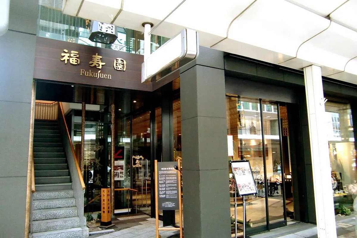 The entrance of Fukujuen's Kyoto shop, with the sign 福寿園 Fukujuen above the door and a staircase beside the doors