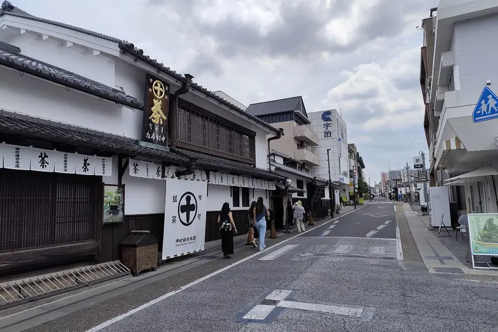 The street in front of Nakamura Tokichi's main store in Uji, a white and dark wooden building with a sign reading 茶