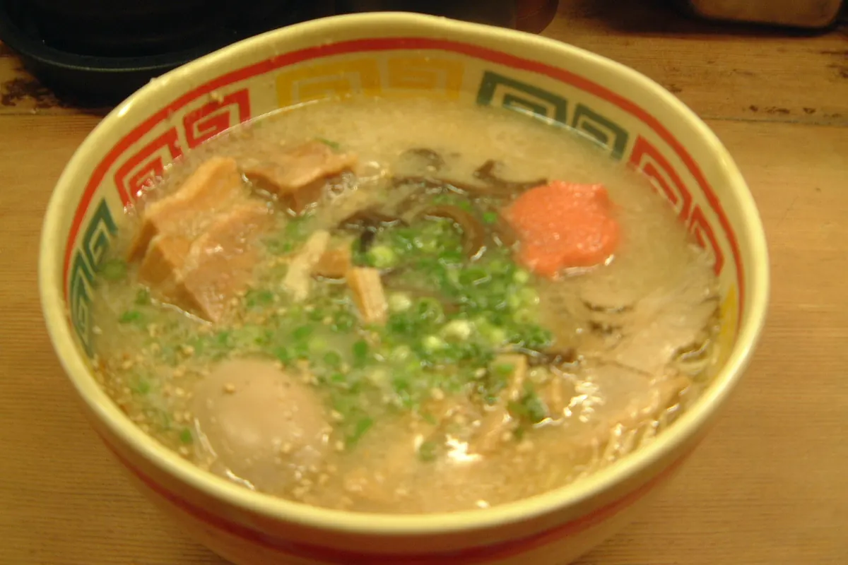Bowl of Kyushu Jangara tonkotsu ramen loaded with toppings including mentaiko, pork, mushrooms, and green onions