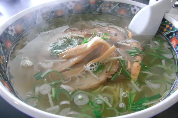 Bowl of Hakodate shio ramen with clear broth, chashu pork, bamboo shoots, and scallions
