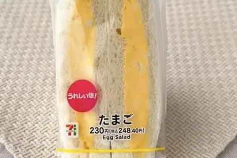 A 7-Eleven egg salad sandwich with a red Ureshii Ne! sticker and a 230 yen label