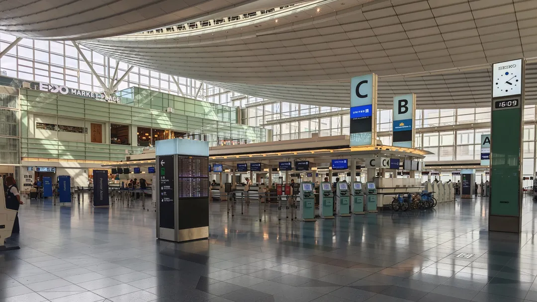 羽田空港第3ターミナルの出発ロビーと、B・Cのチェックインカウンターの案内と時計の写真