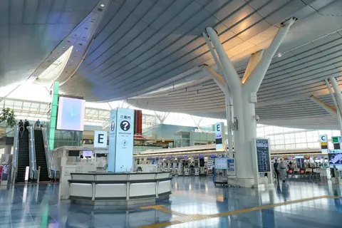 The departure lobby of Haneda Airport Terminal 3, with an information counter and rows of check-in desks.