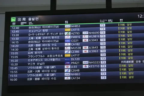 A departures board at Haneda Airport listing a long column of cancelled flights (December 2020).