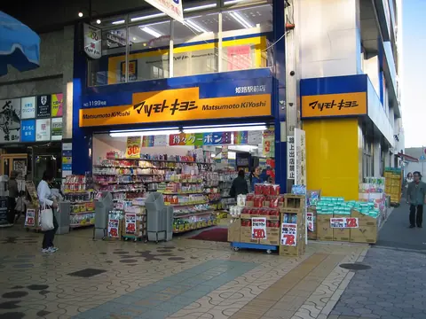 The front of a Matsumoto Kiyoshi drugstore with shelves of goods set out on the pavement.