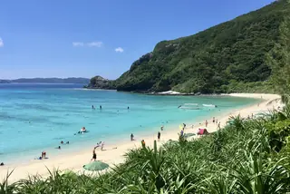 Turquoise water and a white-sand beach backed by green hills at Tokashiku Beach on Tokashiki Island in the Kerama Islands, Okinawa.
