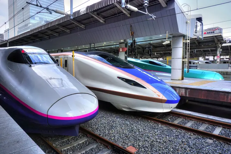 Three shinkansen bullet trains (E2, E7 and E5 series) lined up side by side at the Tohoku/Hokuriku Shinkansen platforms of Tokyo Station.