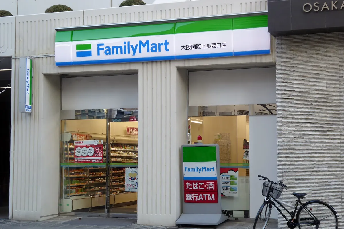 FamilyMart convenience store entrance in Osaka with green and white signage and a bicycle parked outside