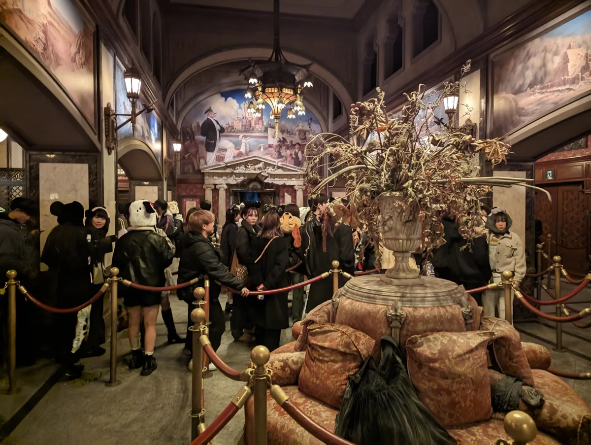Visitors in the ornate indoor queue lobby of the Tower of Terror