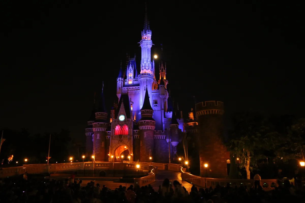 Cinderella Castle lit in purple and pink at night