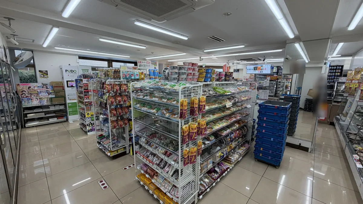 The shop floor of a 7-Eleven in Tokyo, with low shelves and the counter area at the back