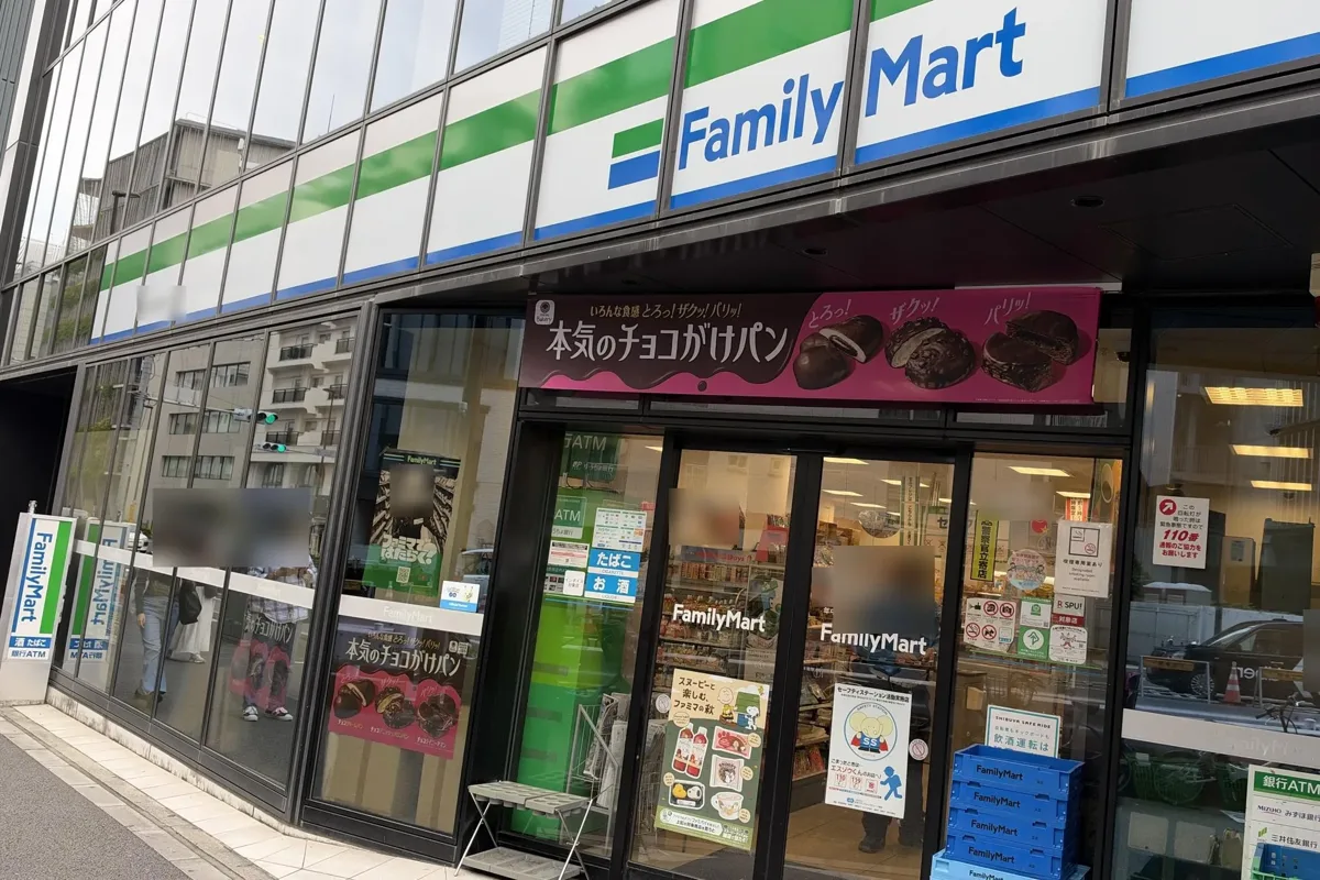 The front of a FamilyMart store in Tokyo, with the green, white and blue sign over the glass doors