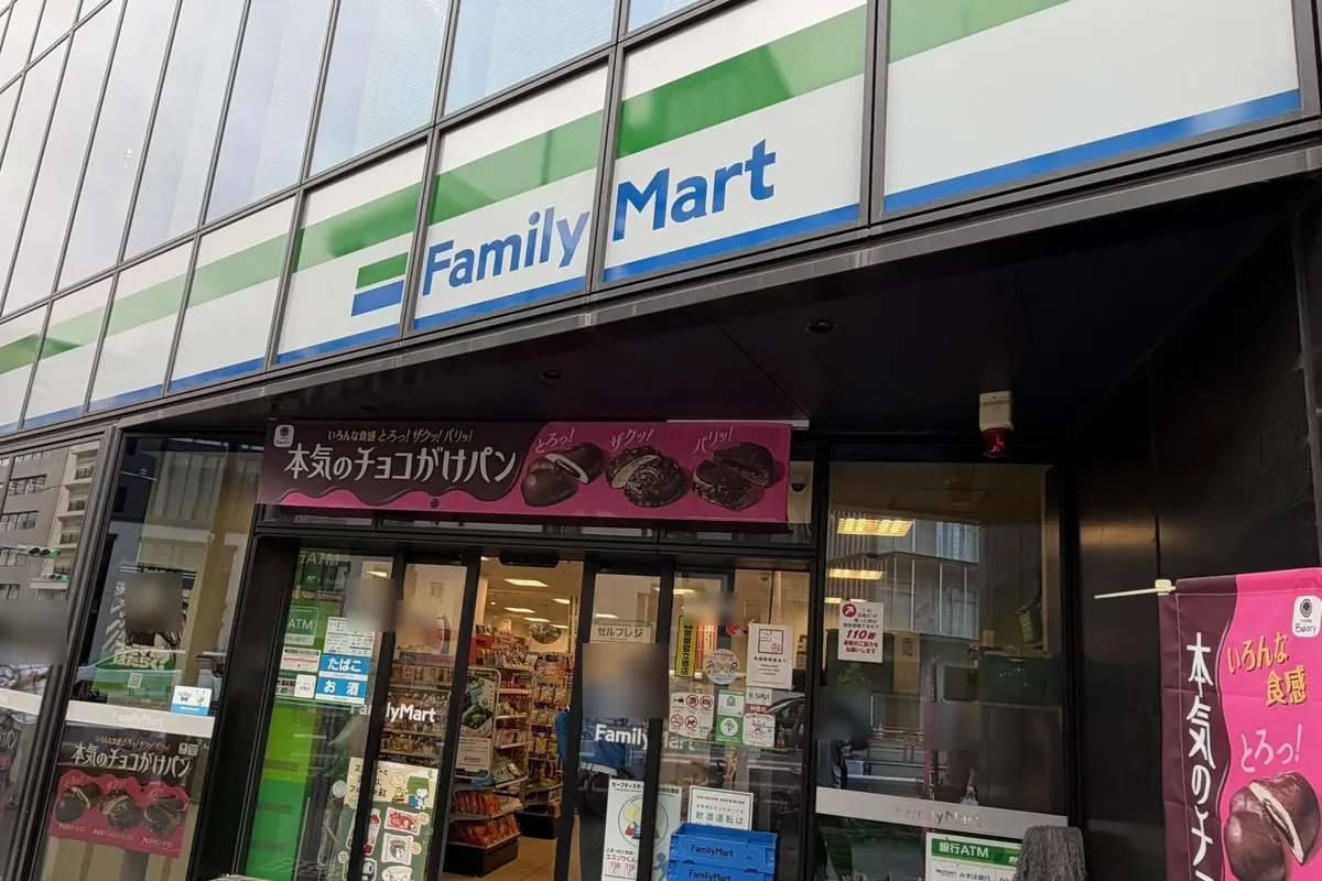 A FamilyMart on a Tokyo street, seen from the side, with a chocolate bread banner by the door