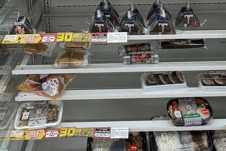Inari sushi and sushi rolls on the lower rows of a 7-Eleven chilled shelf in Tokyo on 20 October 2026