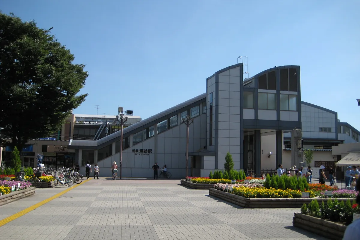相鉄本線瀬谷駅の外観。舗装された広場と花壇、駐輪した自転車が見える