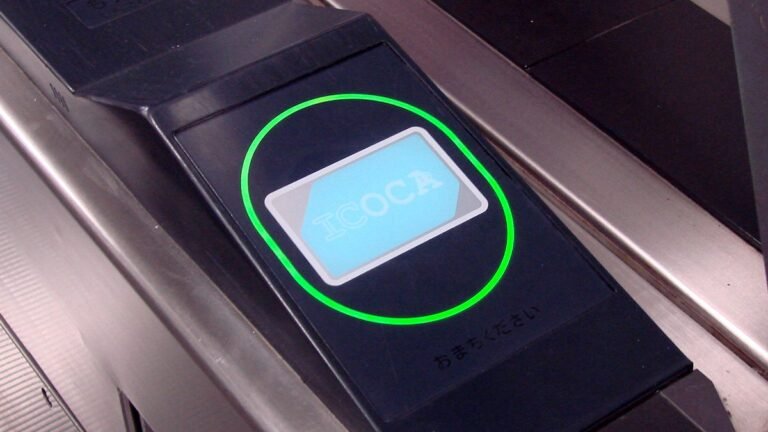 An ICOCA IC card being tapped on a ticket gate reader at a train station in the Kansai region