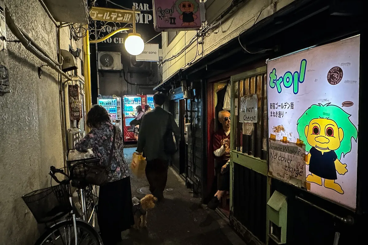 A narrow alley in Shinjuku Golden Gai lined with small bars and their signs