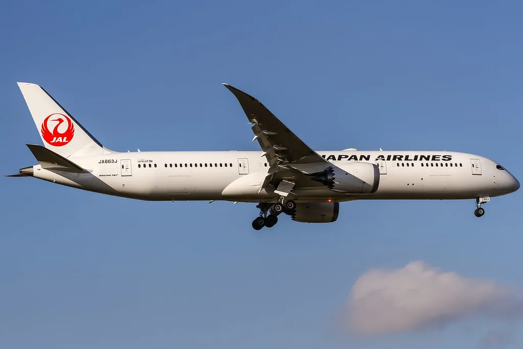 Japan Airlines Boeing 787 Dreamliner in flight with landing gear down and the red crane logo visible on its tail