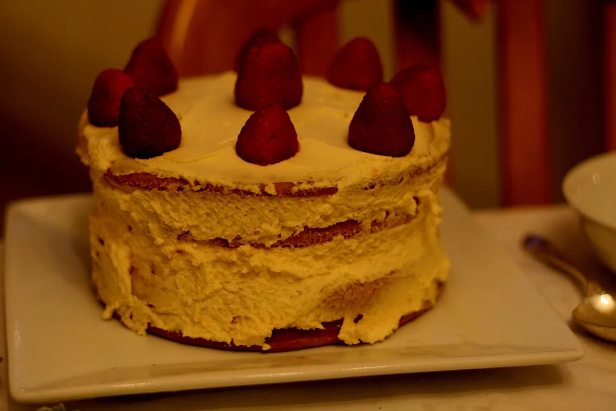 A round Japanese Christmas cake topped with whole strawberries and cream