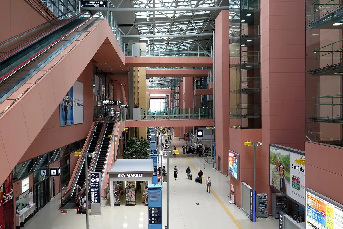関西国際空港第1ターミナルの多層アトリウムにあるエスカレーターとSKY MARKETの店舗