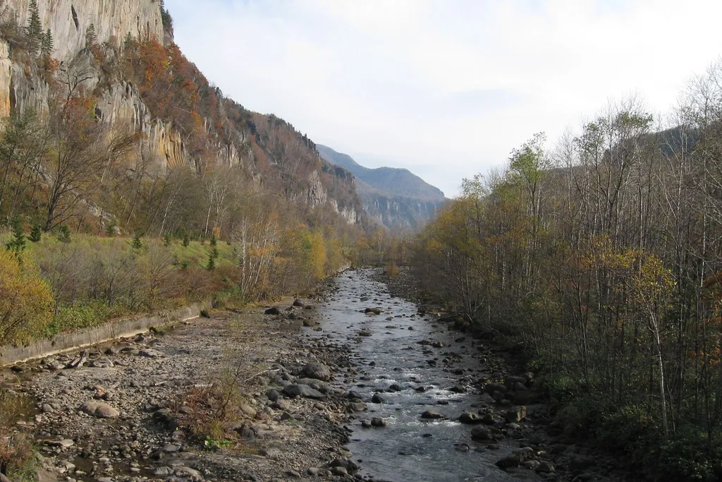 Rocky cliffs and autumn-colored trees along a river at Sounkyo Gorge in Hokkaido