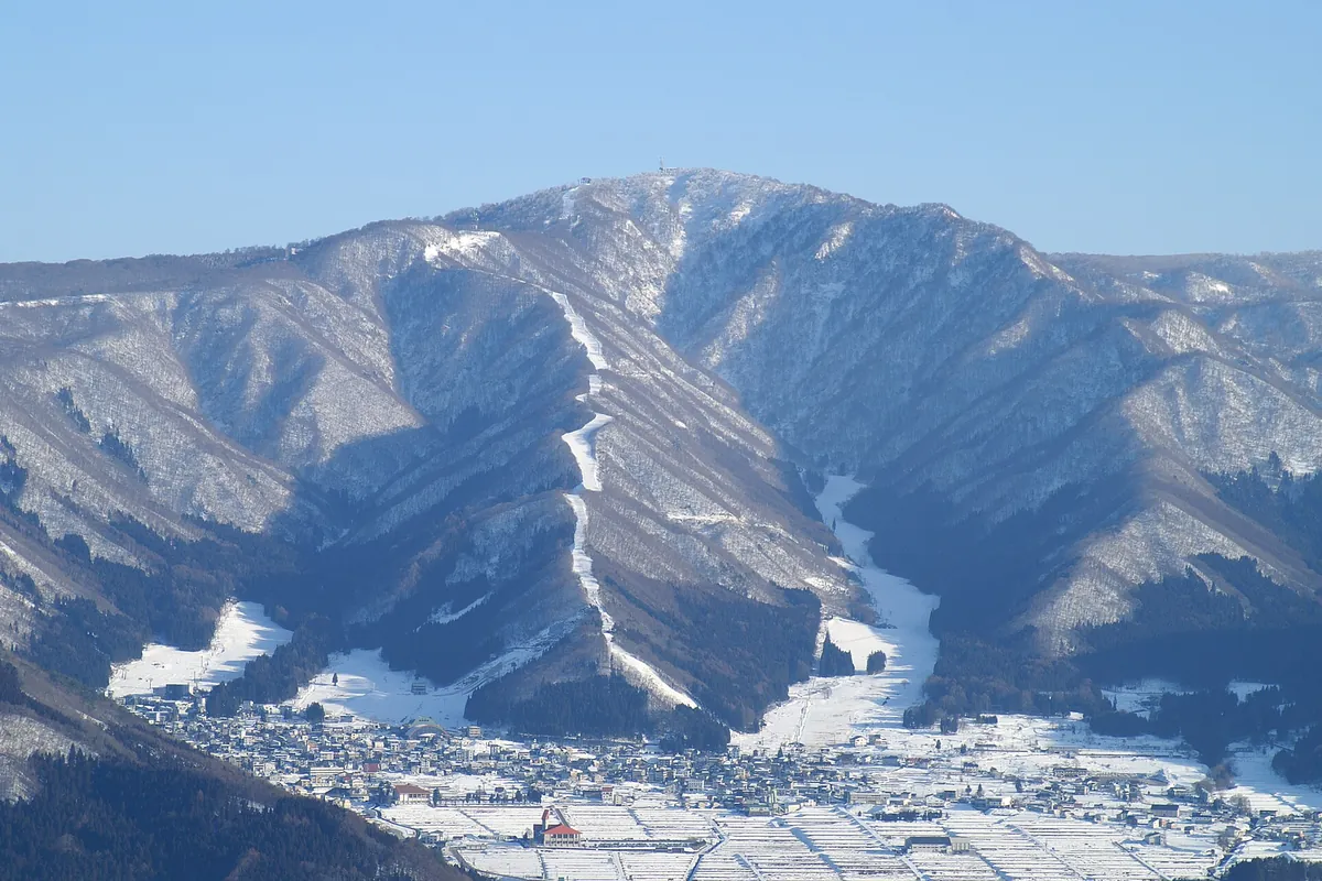 Snow-covered ski slopes on a mountain above the town of Nozawa Onsen in Nagano
