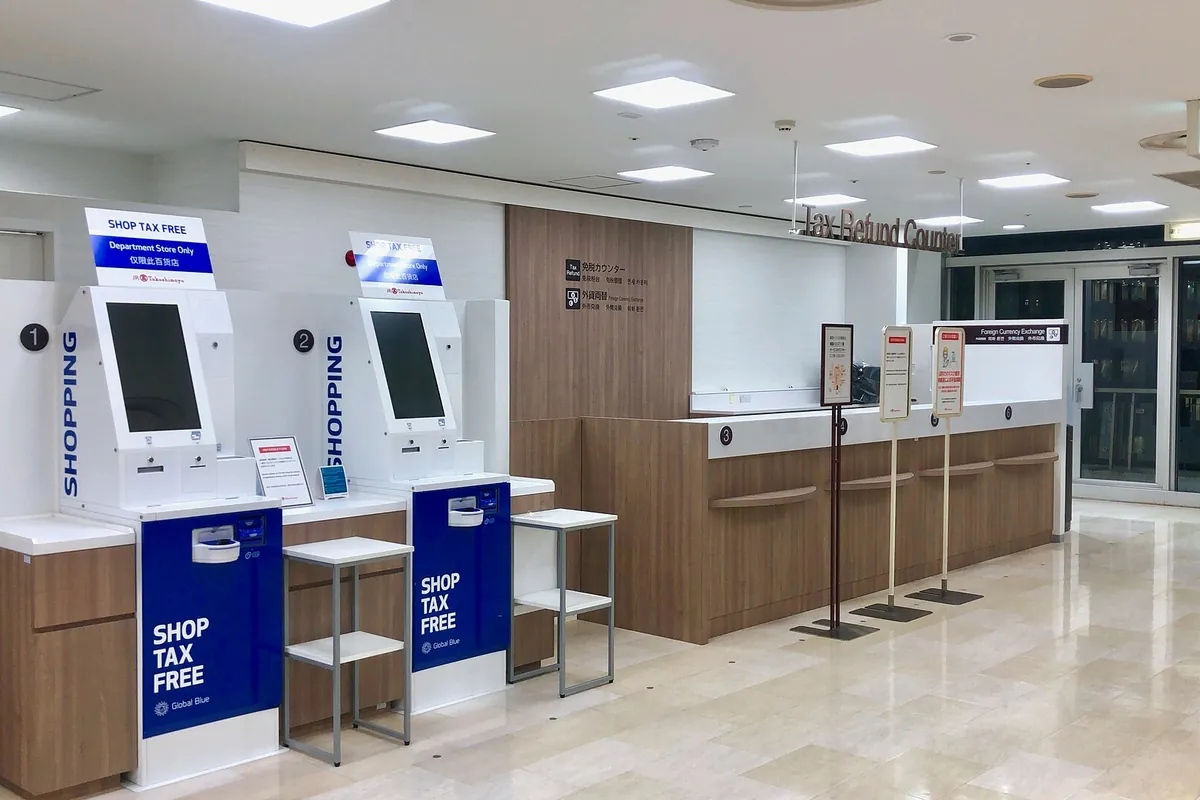 A SHOP TAX FREE sign at the self-service kiosks of a tax refund counter in JR Takashimaya department store, Japan