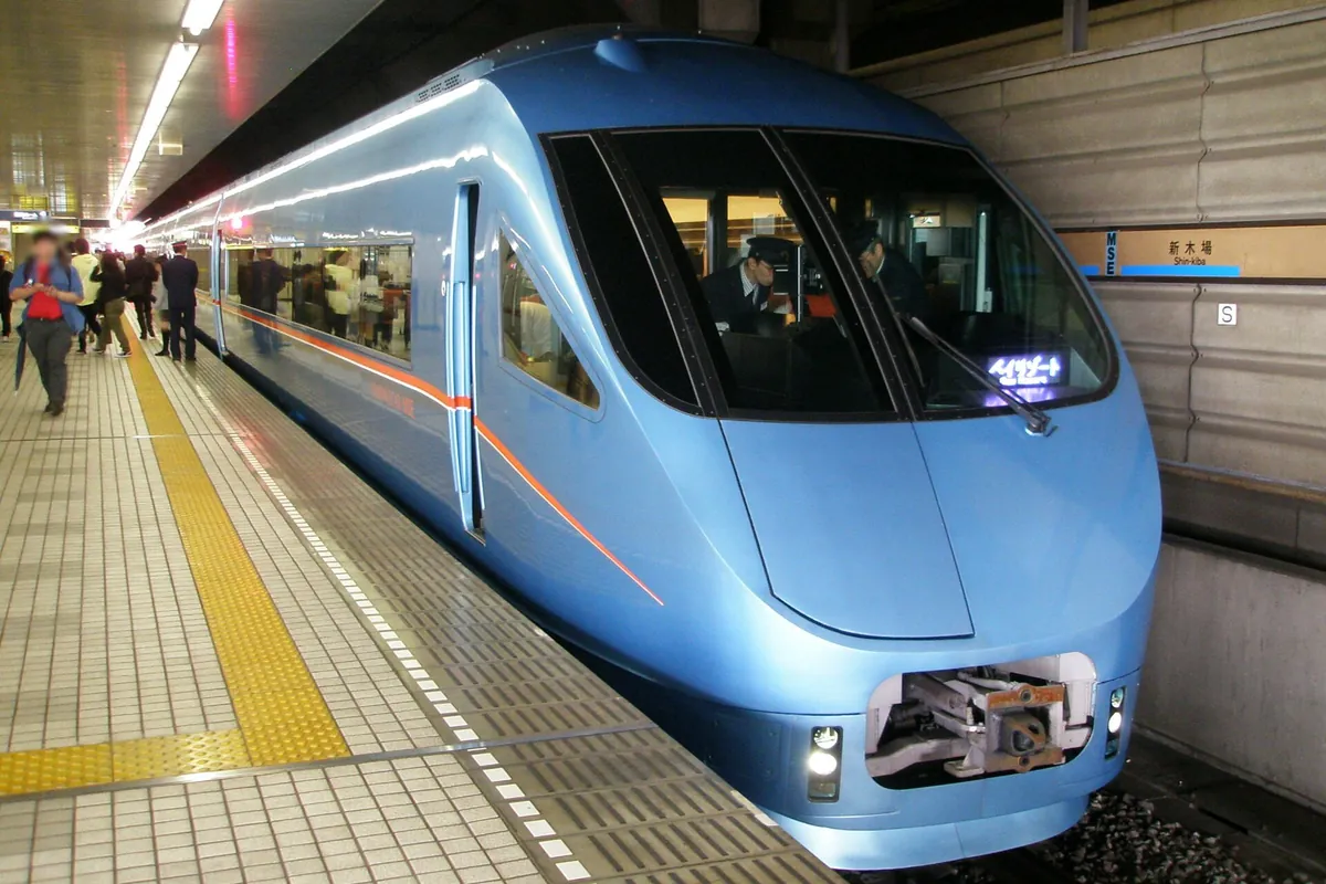 A blue Odakyu Romancecar limited express train stopped at Shin-kiba Station platform in Tokyo